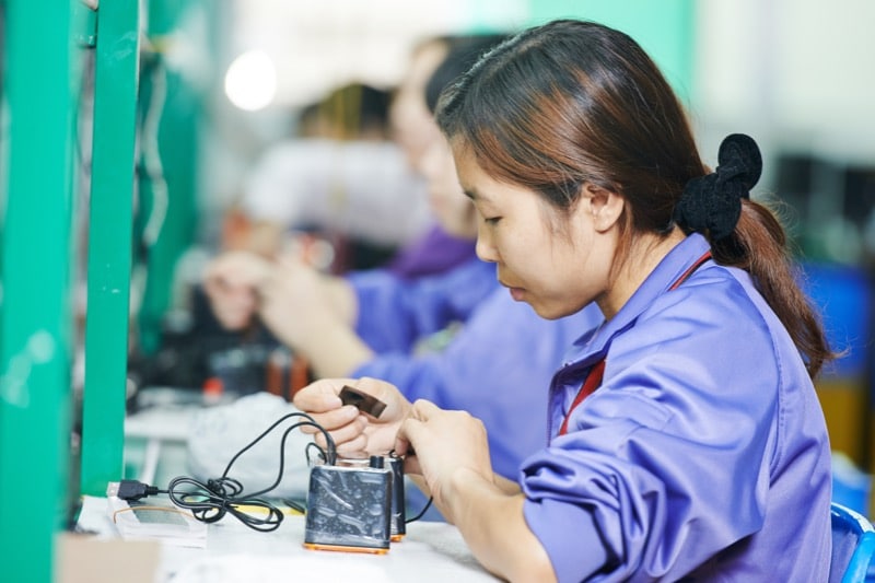 China woman assembling a part in a factory