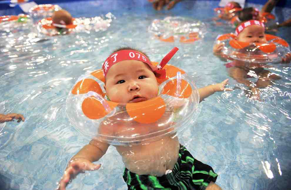 A Chinese baby with a floaty in the water.